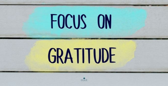 Wall with the words "Focus on Gratitude" pained in black letters |30 Days of Gratitude| Root Nutrition & Education