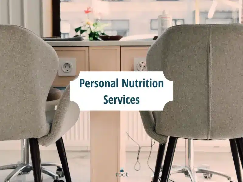 Desk chairs pushed into a pink/salmon desk with the words reading "Personal Nutrition Services" | Root Nutrition & Education